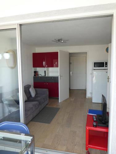 un salon avec un canapé et une cuisine dans l'établissement P2 Couchant 2 étoiles La Grande Motte 5 min Plage-Parking privatif, à La Grande Motte