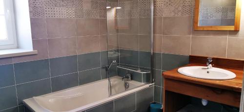 La salle de bains est pourvue d'un lavabo et d'une baignoire à côté d'un lavabo. dans l'établissement Les perles vertes, à Arlempdes