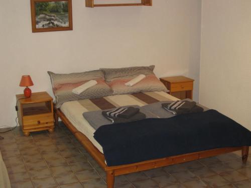 a bedroom with a bed and a night stand at Parti Apartman in Zamárdi