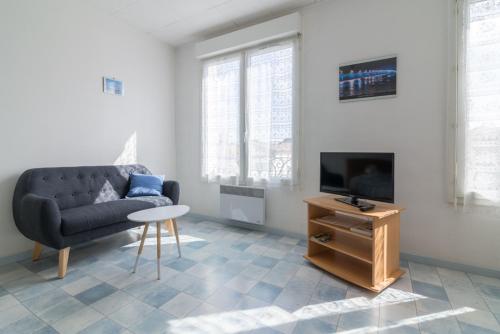 un salon avec un canapé, une télévision et une table dans l'établissement Île de Ré, à Rochefort
