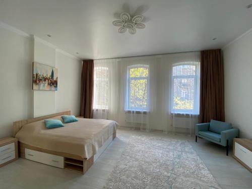 een slaapkamer met een bed en een blauwe stoel bij Modern Apartment in Lviv