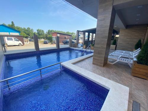 a large swimming pool with blue water in a house at Lemoni Hotel in Anapa