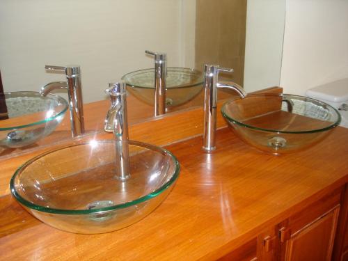 baño con 3 tazones de cristal en una encimera de madera en Manichan Guesthouse, en Luang Prabang