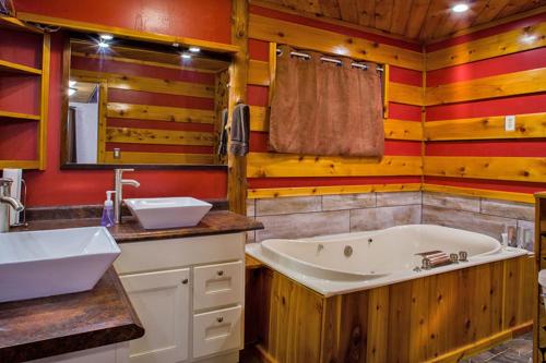 ein Badezimmer mit einer Badewanne, einem Waschbecken und einem Spiegel in der Unterkunft Curriers Lakeview Lodge in Rice Lake