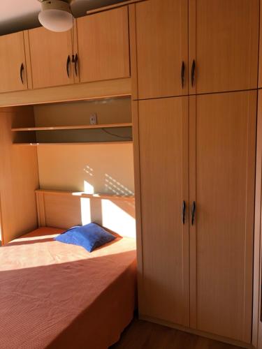 a bedroom with a bed and wooden cabinets at POA zona norte - melhor opção - completíssimo in Porto Alegre