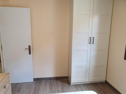 a room with white cabinets and a door in a room at Casas Fontan in Combarro