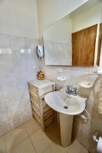 a bathroom with a sink and a phone on the wall at Cozy Cottage Posada Turistica in San Andrés