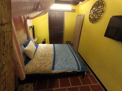 a bedroom with a bed in a room with a tv at 彼岸古厝民宿-包棟優先--Biiann B&B in Jinning