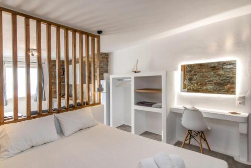 una camera con letto bianco e scrivania di Avissalou Apartments ad Agios Romanos