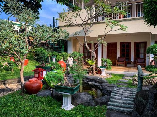 a garden in front of a house with trees at Peti Mas Hotel Malioboro in Yogyakarta
