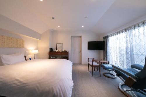a hotel room with a bed and a desk and chairs at Riverte Kyoto Kamogawa in Kyoto