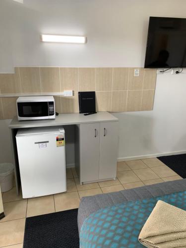 a room with a counter with a microwave on it at Glen Innes Motel in Glen Innes