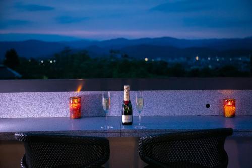 a bottle of wine sitting on a table with wine glasses at Riverte Kyoto Kamogawa in Kyoto