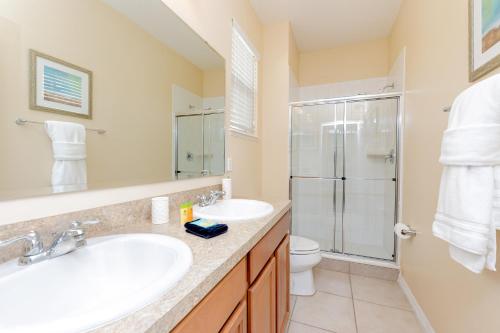 y baño con lavabo, ducha y aseo. en Newly Remodeled 1 story - 5 Bed 5 Bath with Pvt Pool Spa And Game Room, en Kissimmee