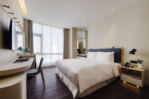 台北的住宿－傑仕堡有氧酒店，酒店客房设有一张大床、一张书桌和一张书桌。