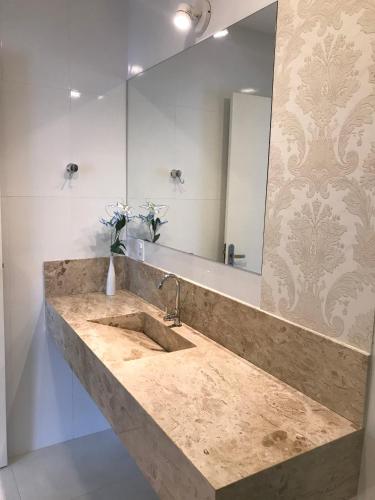 a bathroom with a sink and a large mirror at Guest House Forno in Búzios
