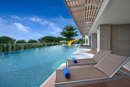 a pool with a blue chair next to it at Centre Point Prime Hotel Pattaya in Pattaya North
