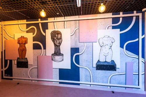 a wall with different types of art on it at The Muse Christchurch Art Hotel in Christchurch
