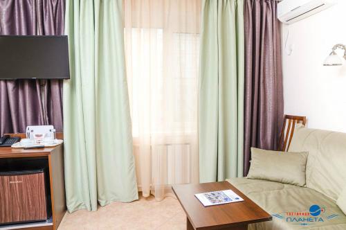 a living room with a couch and a table at Planeta Hotel in Chelyabinsk