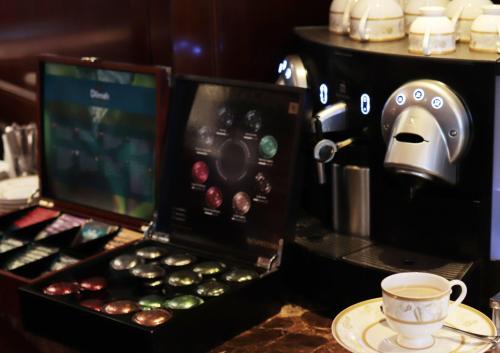 a coffeemaker with a cup of coffee on a table at Marco Polo Hongkong Hotel in Hong Kong