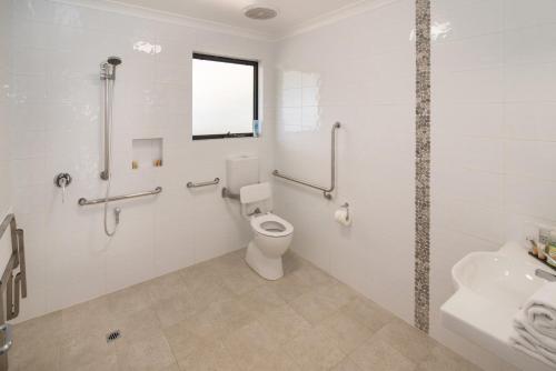 a white bathroom with a toilet and a sink at Redgate Forest Retreat in Witchcliffe