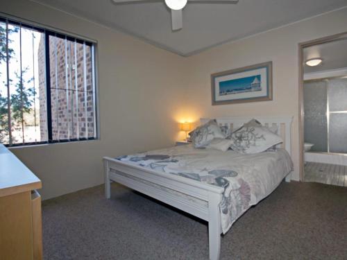 1 dormitorio con cama blanca y ventana en Bay Parklands 44 WI FI Netflix Air Con and Views, en Nelson Bay