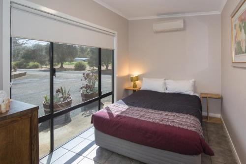 a bedroom with a bed and a large window at Redgate Forest Retreat in Witchcliffe