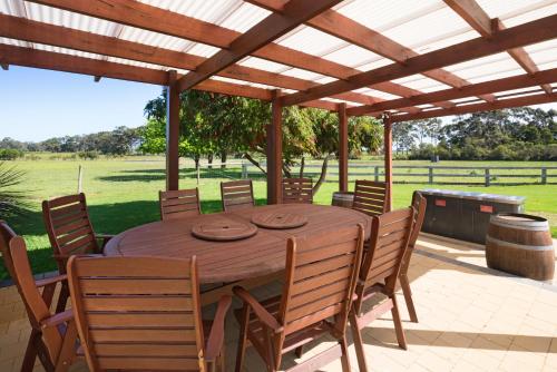 a wooden table and chairs under a wooden pergola at Redgate Forest Retreat in Witchcliffe