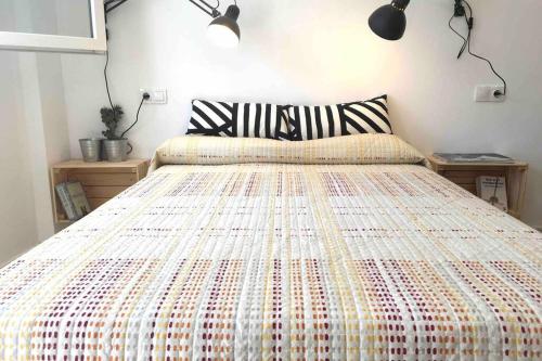 1 dormitorio con 1 cama grande y colcha colorida en Casa La Placeta, en Fortaleny