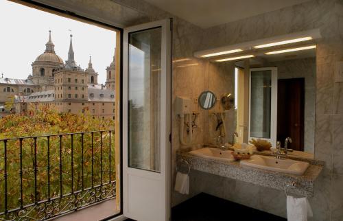 a bathroom with a sink and a balcony with a view at Hotel Florida in San Lorenzo de El Escorial