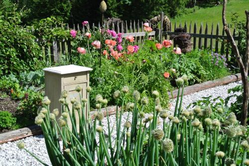 a garden with flowers and a wooden fence at Appartement Seespitzhof in Scheffau am Wilden Kaiser