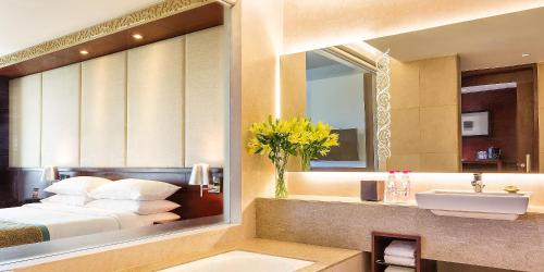 a bathroom with a bed and a sink and a mirror at Crowne Plaza Ahmedabad City Centre by IHG in Ahmedabad