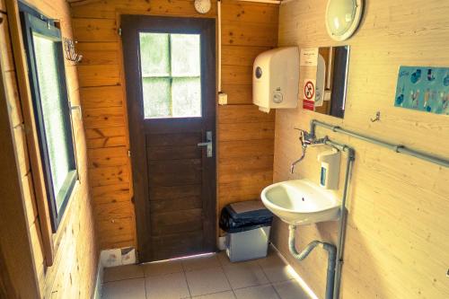 a small bathroom with a sink and a door at Chatky-Bítov 399 in Bítov