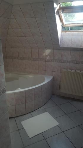 łazienka z wanną i oknem w obiekcie Bliss apartment w mieście Tata