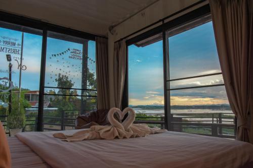 a bed with a towel in the shape of a heart at INBOX Living Rimkhong in Chiang Khan