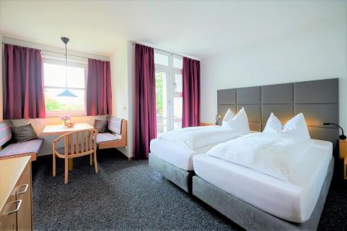 a hotel room with a large bed and a desk at Hotel Bannwaldsee in Halblech