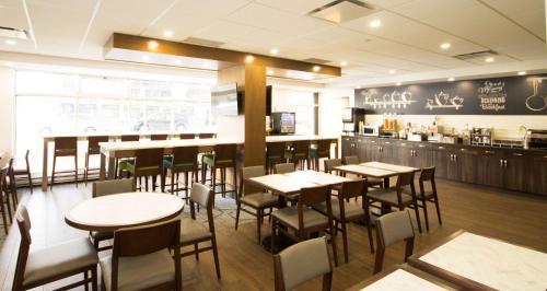 a restaurant with tables and chairs and a bar at Best Western Plus Suites Downtown Calgary in Calgary