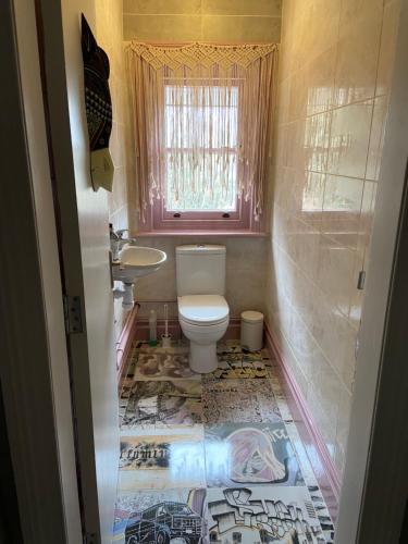 a small bathroom with a toilet and a sink at The Boho - 4 min walk to beach & town in Bournemouth