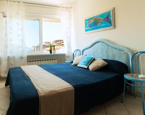 a bedroom with a blue bed with a window at Sea & Culture in Lerici