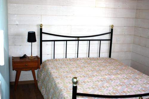 a bedroom with a bed and a table with a lamp at Au Macareux in Gruissan