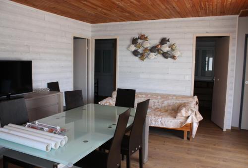 une salle à manger avec une table en verre et un canapé dans l'établissement Au Macareux, à Gruissan