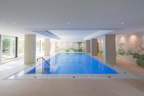 ein großer Pool mit blauem Wasser in einem Gebäude in der Unterkunft Insel-Hotel Heilbronn in Heilbronn