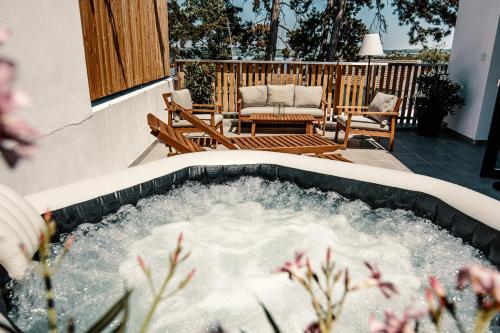 a hot tub on a patio with a table and chairs at Sousedi Pavlov in Pavlov