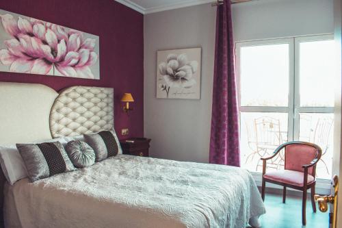 a bedroom with a bed and a chair and a window at La Morona Hotel in Morón de la Frontera