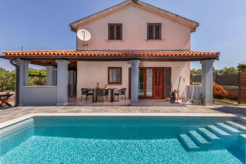 a villa with a swimming pool in front of a house at Casa Vian in Pula