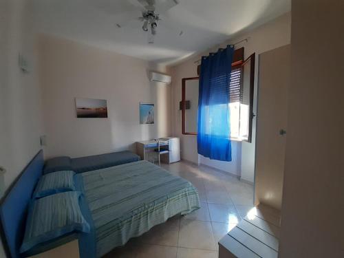 a bedroom with a blue bed and a window at G&G - Bed & Breakfast in Vieste