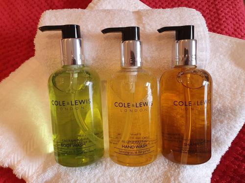 three bottles of soap are sitting on a towel at Herdwick Guest House in Keswick