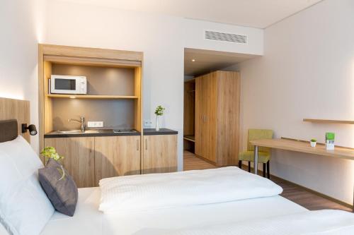 a hotel room with a bed and a microwave at Aparthotel Am Pfaffenstein in Klein-Winternheim
