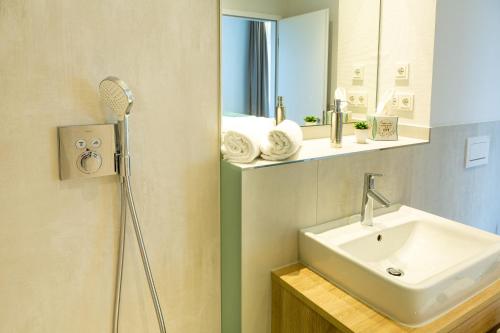 a bathroom with a sink and a mirror at Aparthotel Am Pfaffenstein in Klein-Winternheim