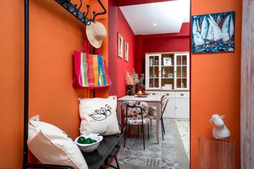 a kitchen with orange walls and a dining room at Casa de Colores en Corfu! in Corfu Town